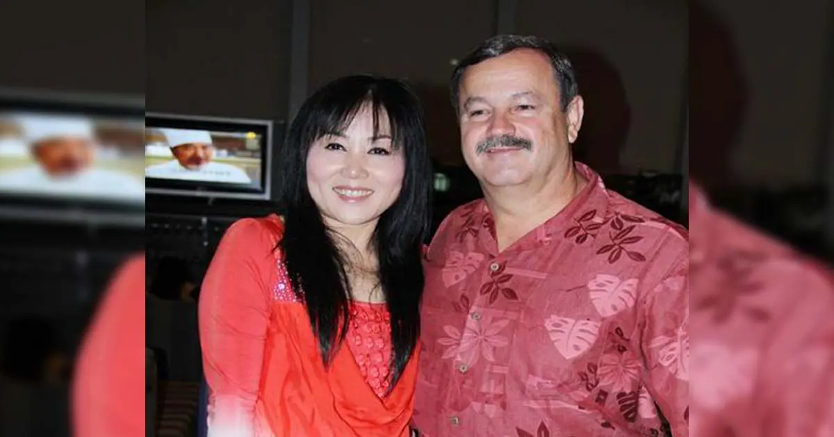 A Chinese woman posing for a photo beside a Caucasian man.