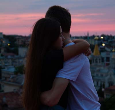 Man and woman hugging at sunset.